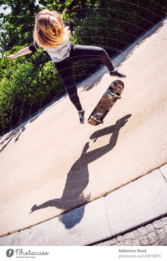 Skateboarderin, die Ollie im Park übt. asiatisch Aktion Außenaufnahme Sonnenlicht Rampe Skateboarding verpflichtet entschlossen Bewegung Mensch 1 Frau Energie