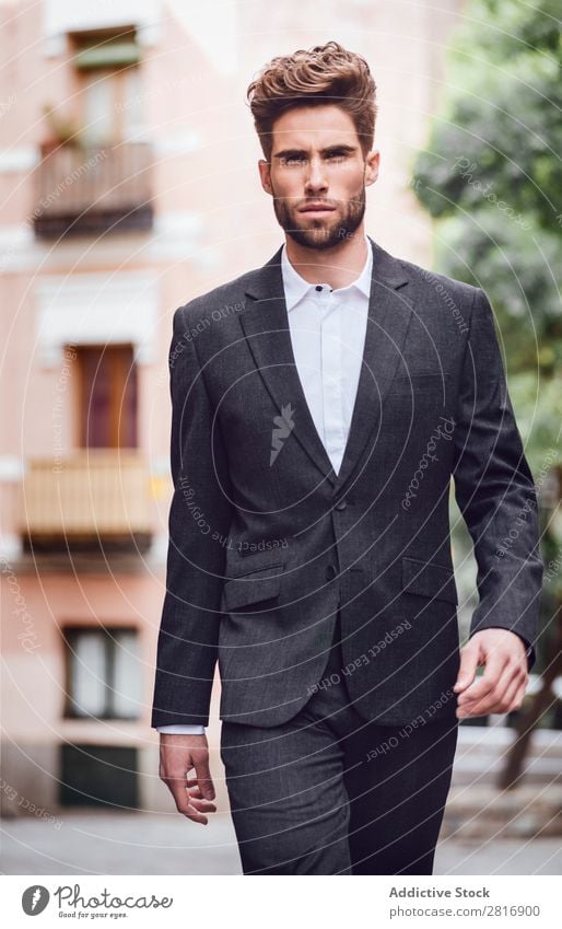 Schöner, eleganter Mann der jungen Mode im trendigen Kostümanzug, der die Straße entlanggeht. Anzug Herr modisch Bekleidung Stil Model Hemd Hand lässig modern