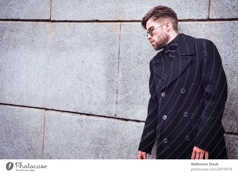 Junger, gutaussehender, trendiger Mann mit Mantel, der auf der Treppe posiert. Erwachsene attraktiv Vollbart bärtig lässig Kaukasier Coolness niedlich tief