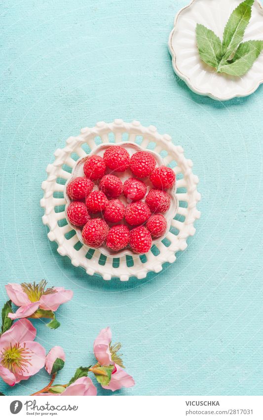 Himbeeren auf hellblauem Hintergrund Lebensmittel Frucht Dessert Ernährung Frühstück Bioprodukte Vegetarische Ernährung Diät Teller Stil Design