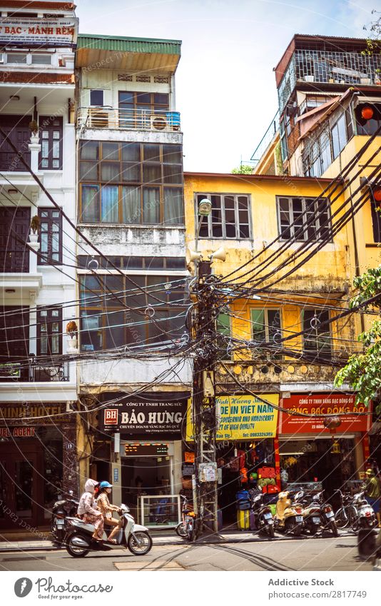 HANOI, VIETNAM - 17. JUNI 2015: Motorräder, die auf einer typischen Straße in Hanoi mit vielen elektrischen Polen und Kabeln laufen, am 17. Juni 2015 in Hanoi, Vietmam.