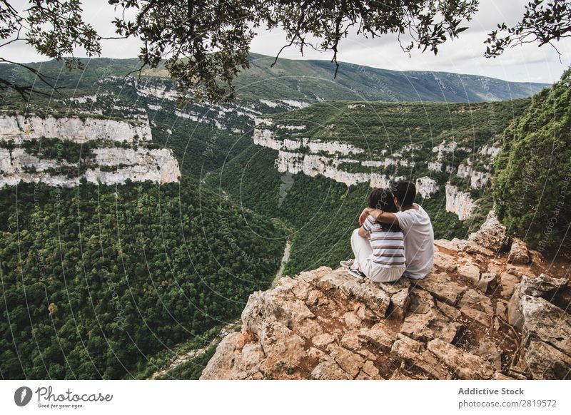 Ein Paar sitzt auf einer Klippe. Landschaft Natur Ferien & Urlaub & Reisen Felsen Abenteuer Mann Frau Freiheit Zusammensein Partnerschaft Jugendliche Liebe