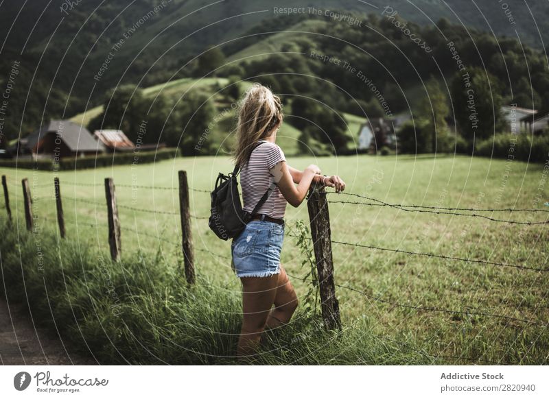 Frau steht am ländlichen Zaun. Feld Jugendliche schön Natur Mädchen Porträt grün stehen Ferien & Urlaub & Reisen Lifestyle Rucksack Wiese Bauernhof Mensch