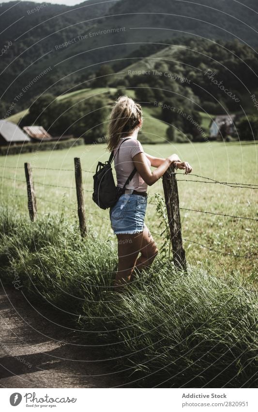 Frau steht am ländlichen Zaun. Feld Jugendliche schön Natur Mädchen Porträt grün stehen Ferien & Urlaub & Reisen Lifestyle Rucksack Wiese Bauernhof Mensch