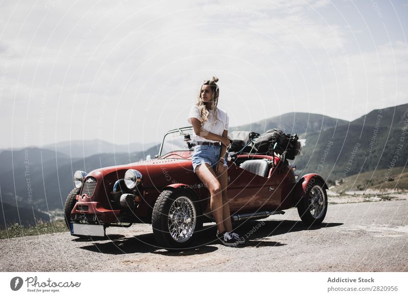 Frau steht am Oldtimer. PKW altehrwürdig Straße rot anlehnen Motorhaube stehen Berge u. Gebirge Mädchen Jugendliche Laufwerk Fahrzeug Lifestyle Sommer schön