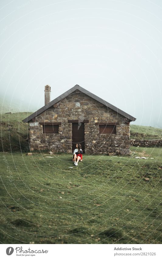 Frau auf dem Landhaus sitzend Landschaft Haus Natur Gras grün Länder Jugendliche Lifestyle schön Dorf lässig Porträt Konstruktion Cottage Gebäude heimisch