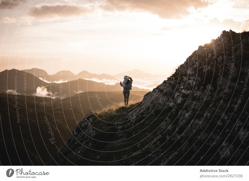 Hübsche Frau, die in den Bergen wandert. laufen Hut Tal Körperhaltung romantisch Sonnenuntergang Berge u. Gebirge Ferien & Urlaub & Reisen Top Felsen Freiheit