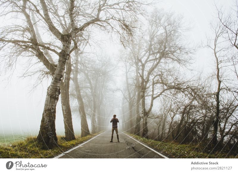 Mann auf nebliger Straße stehend Wald Nebel Herbst Mensch Natur Asphalt Licht Landschaft Morgen Jahreszeiten Blatt schön Wetter Länder Park mehrfarbig elegant