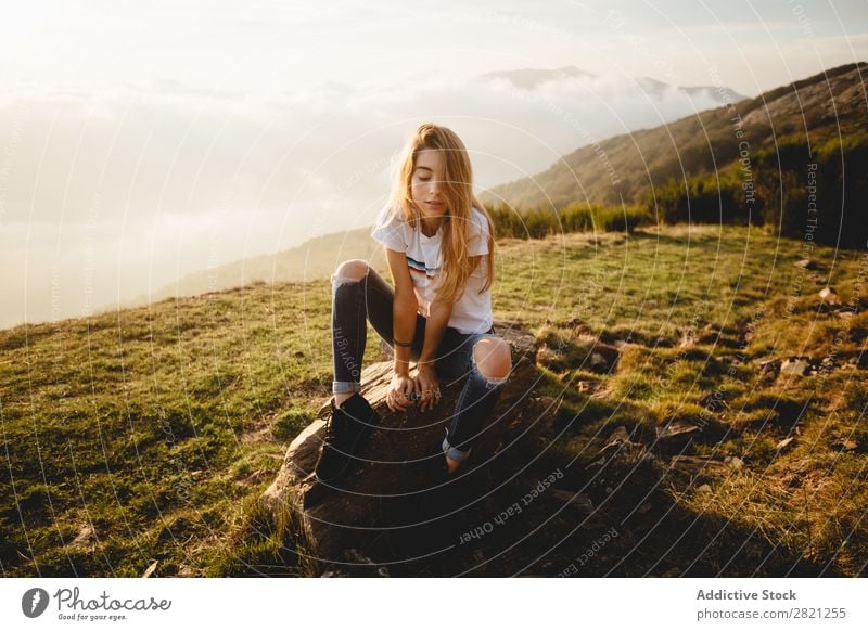 Junge Frau sitzt auf Stein Natur Freiheit Lifestyle Mensch Freizeit & Hobby Sonnenlicht Sonnenstrahlen Tag schön lieblich charmant niedlich Gras Unbekümmertheit