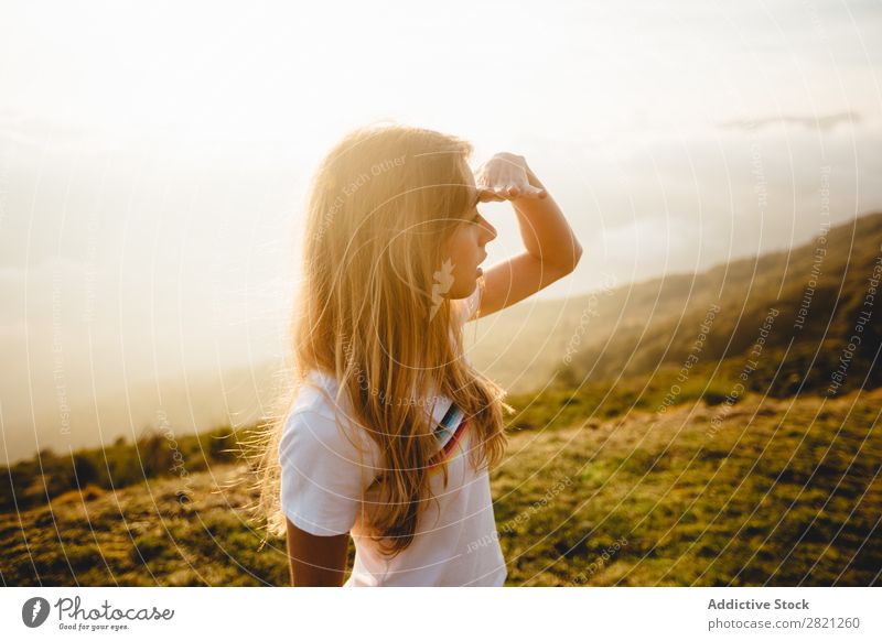 Junge Frau, die in die Ferne schaut. Natur genießend Freiheit Lifestyle Mensch Freizeit & Hobby Sonnenlicht Sonnenstrahlen Tag schön lieblich charmant niedlich