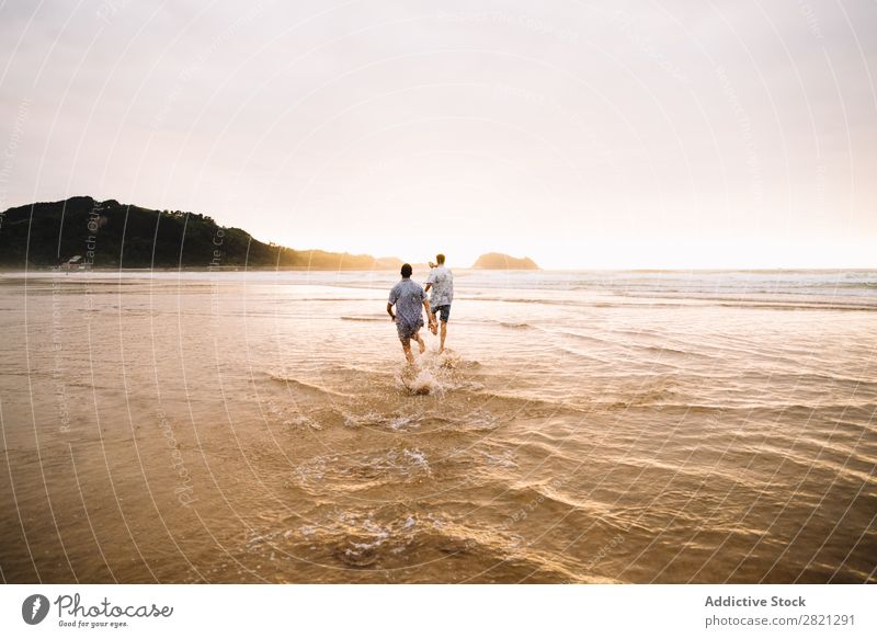 Männer, die zum Meer gehen. Mann laufen Strand Zusammensein Freundschaft Paar Homosexualität Wasser Sand Ferien & Urlaub & Reisen Jugendliche alternativ Natur