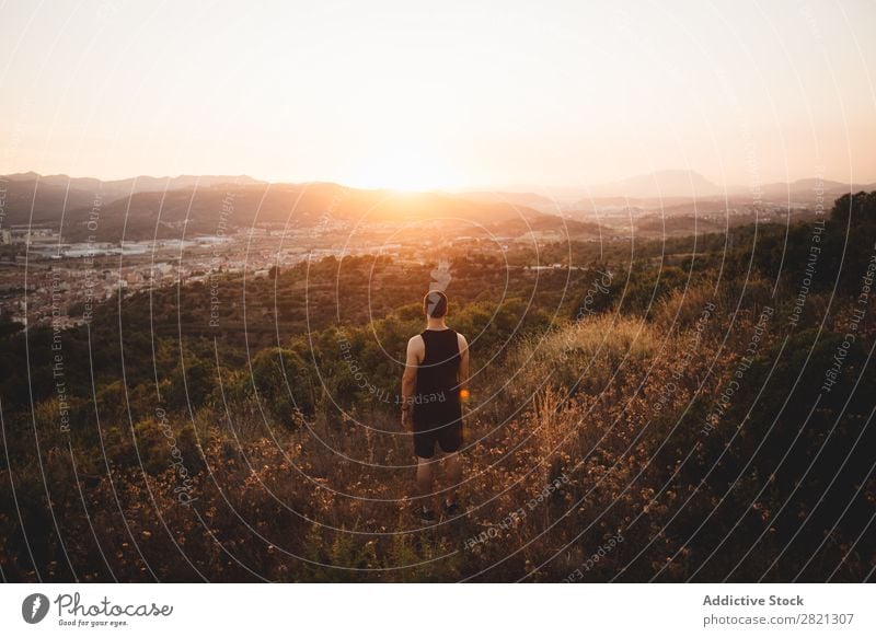 Anonymer Mann, der in der Ebene posiert. Landschaft Feld Sonnenuntergang Natur Sommer Wiese Aktion ländlich Umwelt Abenteuer Freizeit & Hobby Abend natürlich