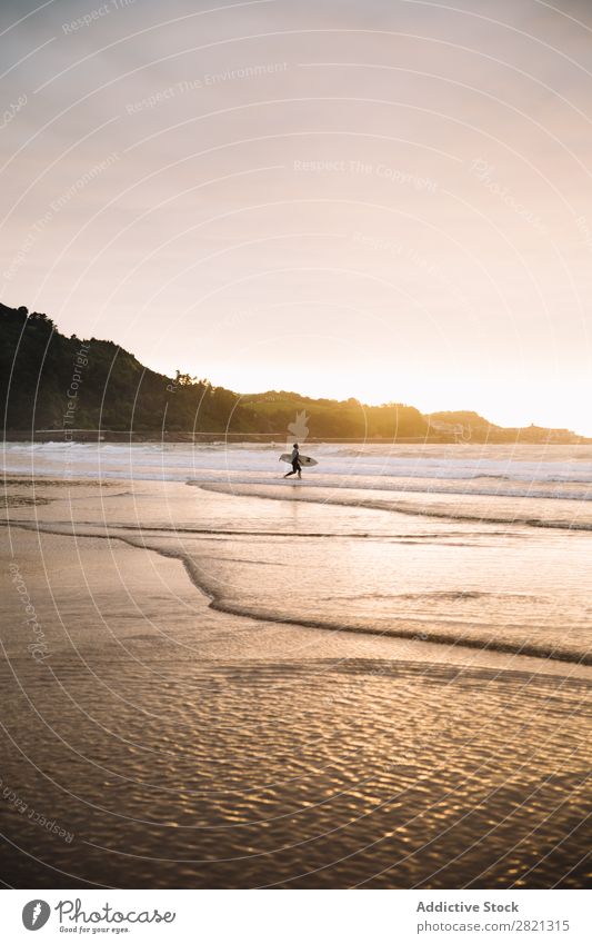 Anonymer Surfer mit Board im Wasser Mensch Strand Abenteuer Sport Küste Sonnenuntergang Urwald Holzplatte Aktion in Bewegung Meer Ferien & Urlaub & Reisen