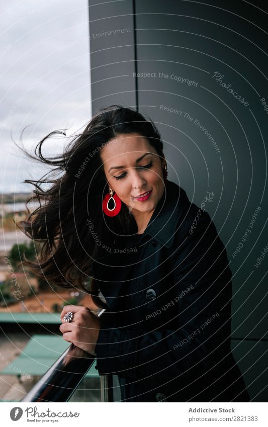 Fröhliche Frau am Handlauf stehend hübsch Jugendliche schön heiter Lächeln Balkon Gebäude modern Zeitgenosse brünett attraktiv Mensch Beautyfotografie