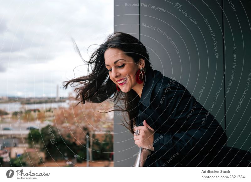 Fröhliche Frau am Handlauf stehend hübsch Jugendliche schön heiter Lächeln Balkon Gebäude modern Zeitgenosse brünett attraktiv Mensch Beautyfotografie