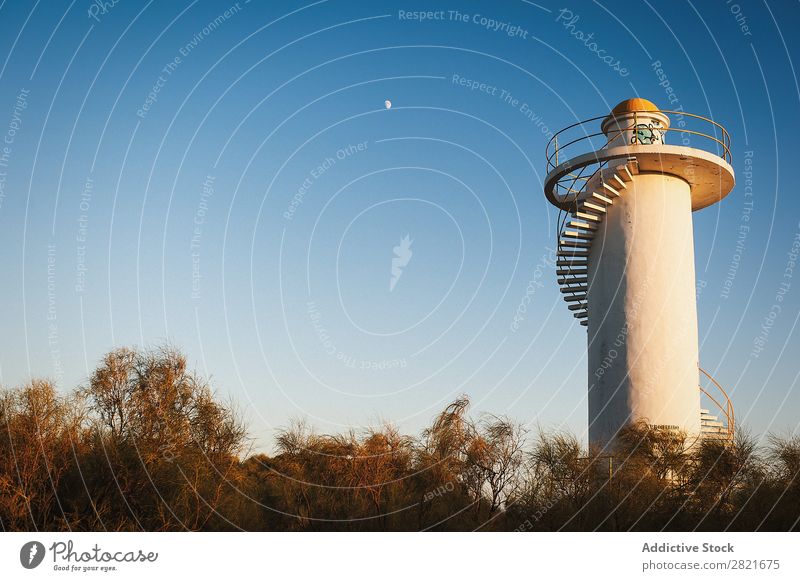 Leuchtturm über strahlend blauem Himmel mit Halbmond Mond Sonnenstrahlen Baum Gebäude weiß Treppe horizontal Hintergrundbild anschaulich Abend Sonnenuntergang