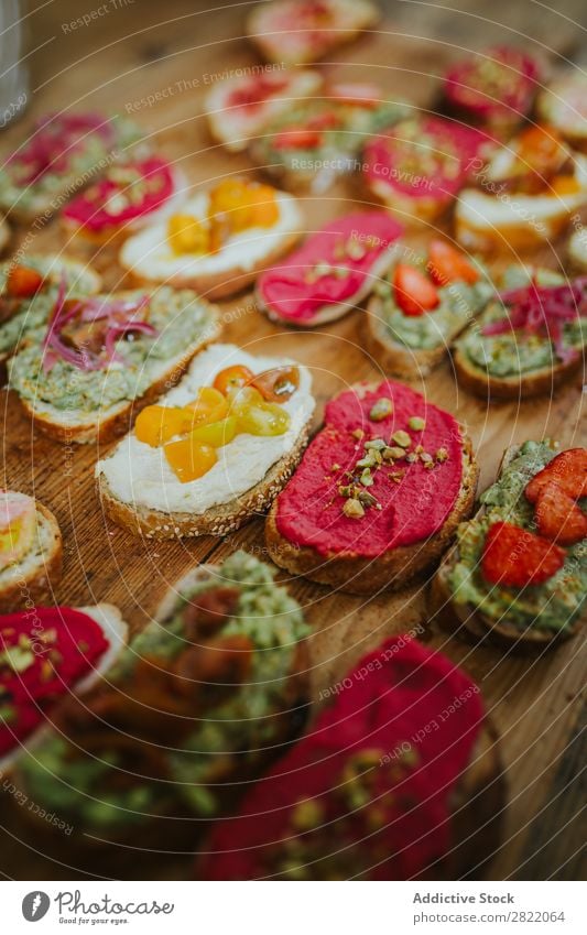 Verschiedene Snacks auf Brot serviert Belegtes Brot Sortiment Holzplatte Lebensmittel frisch Käse Mittagessen Gesundheit Mahlzeit Frühstück Tomate Gemüse