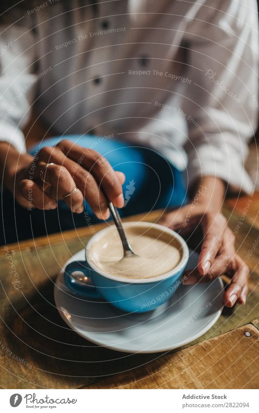 Getreidefrau, die eine Tasse Kaffee rührt. Frau schön urwüchsig schwarz Feldfrüchte Jugendliche Afrikanisch rühren Latte brünett attraktiv Mensch