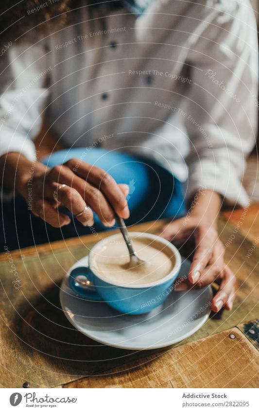 Getreidefrau, die eine Tasse Kaffee rührt. Frau schön urwüchsig schwarz Feldfrüchte Jugendliche Afrikanisch rühren Latte brünett attraktiv Mensch