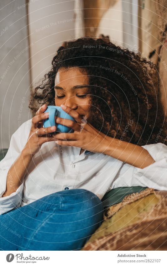 Frau trinkt eine Tasse Kaffee. schön urwüchsig schwarz Jugendliche Afrikanisch rühren Latte brünett attraktiv Mensch Beautyfotografie Erwachsene Stil niedlich