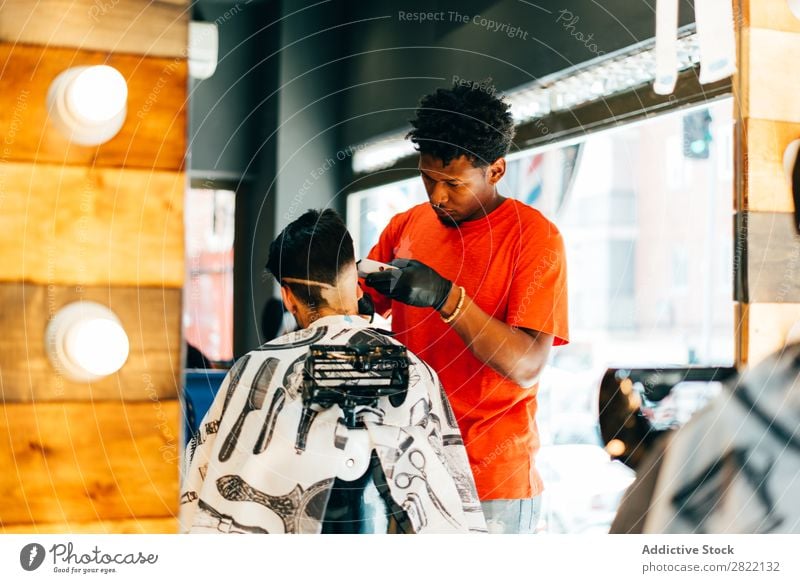 Friseur mit Pflegemaschine Friseursalon Kunde Haarkleid Behaarung Salon schwarz Mann Jugendliche Klient Haare schneiden Haare & Frisuren Fürsorge professionell