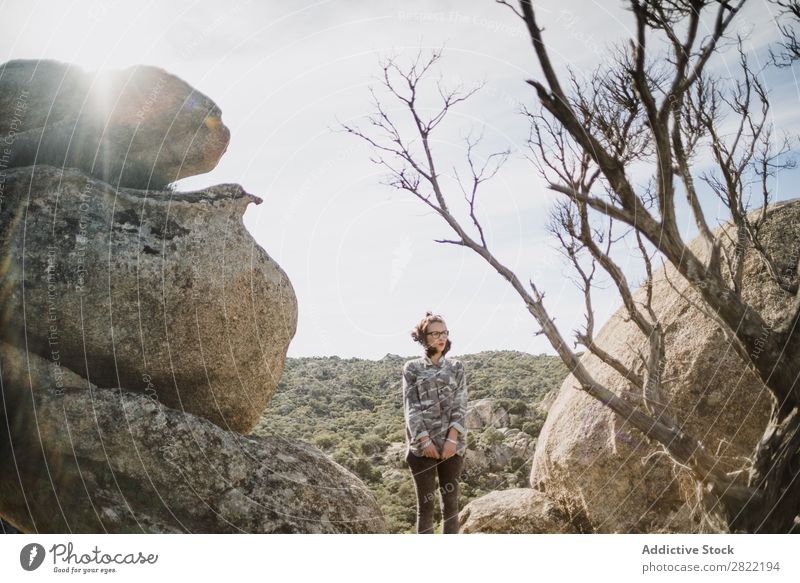 Hübsche junge Frau steht auf einer Klippe. Stil Natur Felsen Stein stehen Sonnenstrahlen Tag attraktiv schön Jugendliche Mode Schickimicki hübsch Coolness