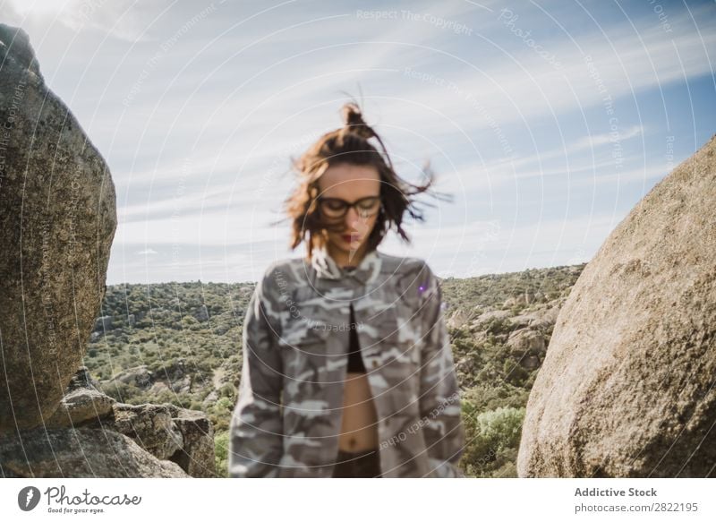 Hübsche junge Frau steht auf einer Klippe. Stil Natur Felsen Stein stehen Sonnenstrahlen Tag attraktiv schön Jugendliche Mode Schickimicki hübsch Coolness