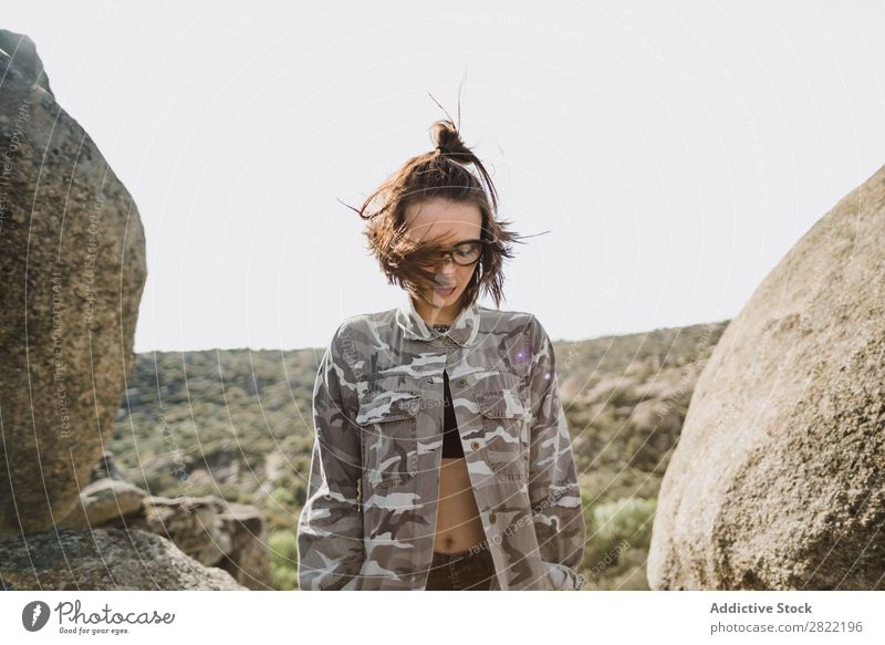 Hübsche junge Frau steht auf einer Klippe. Stil Natur Felsen Stein stehen Sonnenstrahlen Tag attraktiv schön Jugendliche Mode Schickimicki hübsch Coolness