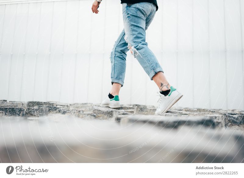 Junge Frau geht auf dem Bürgersteig spazieren Stil Straßenbelag alt laufen schön Jugendliche Mode Schickimicki hübsch Coolness Beautyfotografie attraktiv