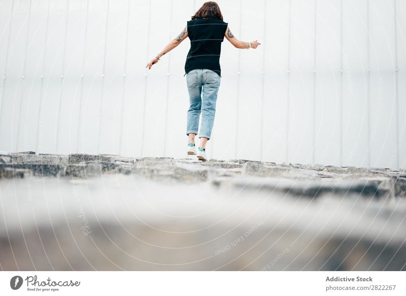 Junge Frau geht auf dem Bürgersteig spazieren Stil Straßenbelag alt laufen schön Jugendliche Mode Schickimicki hübsch Coolness Beautyfotografie attraktiv