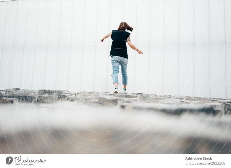 Junge Frau geht auf dem Bürgersteig spazieren Stil Straßenbelag alt laufen schön Jugendliche Mode Schickimicki hübsch Coolness Beautyfotografie attraktiv