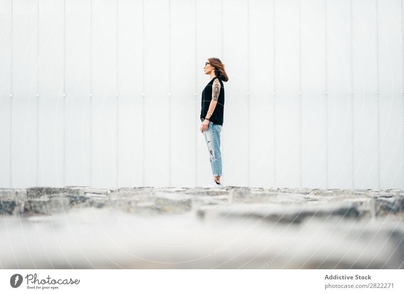 Junge Frau mit Tattoos auf dem Bürgersteig stehend Stil Straßenbelag alt schön Jugendliche Mode Schickimicki hübsch Coolness Beautyfotografie attraktiv Porträt