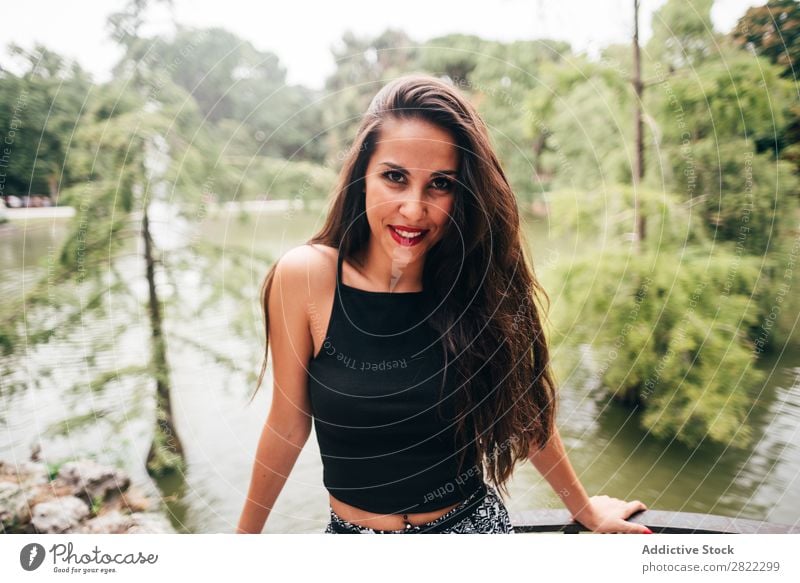 Brünette Frau, die sich auf den Handlauf am Fluss lehnt. hübsch Jugendliche schön brünett attraktiv Mensch Beautyfotografie Erwachsene Stil niedlich Lifestyle