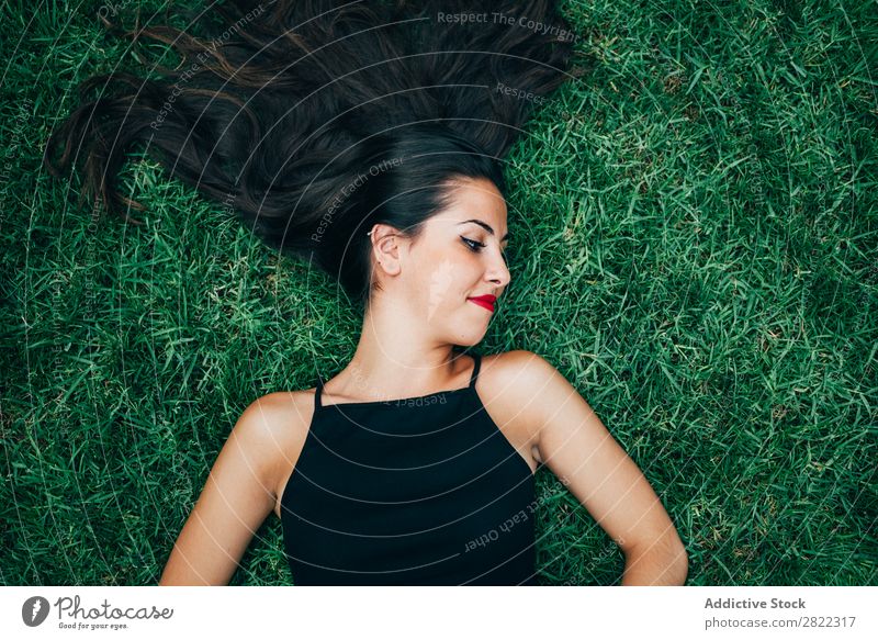 Fröhliche brünette Frau im Gras liegend hübsch Jugendliche schön heiter lügen Natur attraktiv Mensch Beautyfotografie Erwachsene Stil niedlich Lifestyle Dame