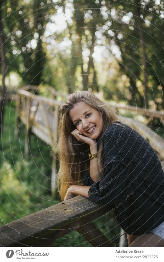 Junge Frau, die sich auf ein Brückengeländer stützt. Reling Natur Mensch hübsch schön Freizeit & Hobby Sommer Porträt Sonnenstrahlen Tag Baum Jugendliche