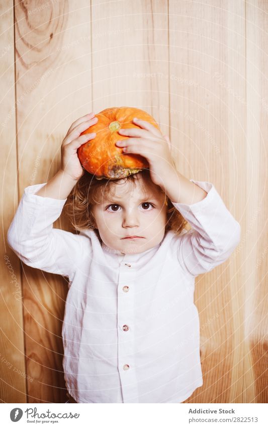 Liebenswertes Kind mit Kürbis auf dem Kopf Körperhaltung Ferien & Urlaub & Reisen Halloween Herbst Menschliches Gesicht Kindheit Zauberei u. Magie Phantasie