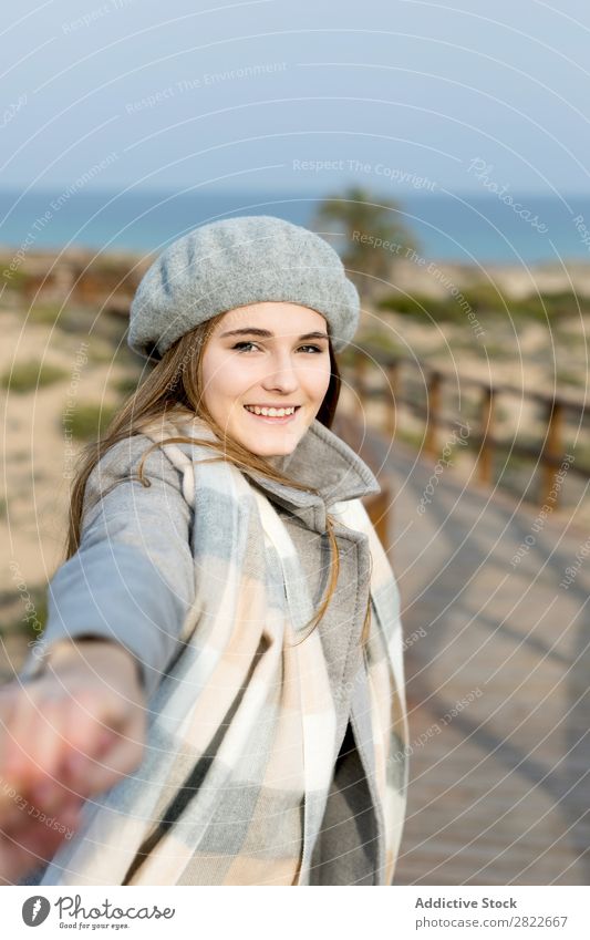 Stilvolle Frau hält die Hand des Fotografen. hübsch Jugendliche schön attraktiv Promenade Gang Holz Natur Baskenmütze mir folgen gestikulieren Mensch