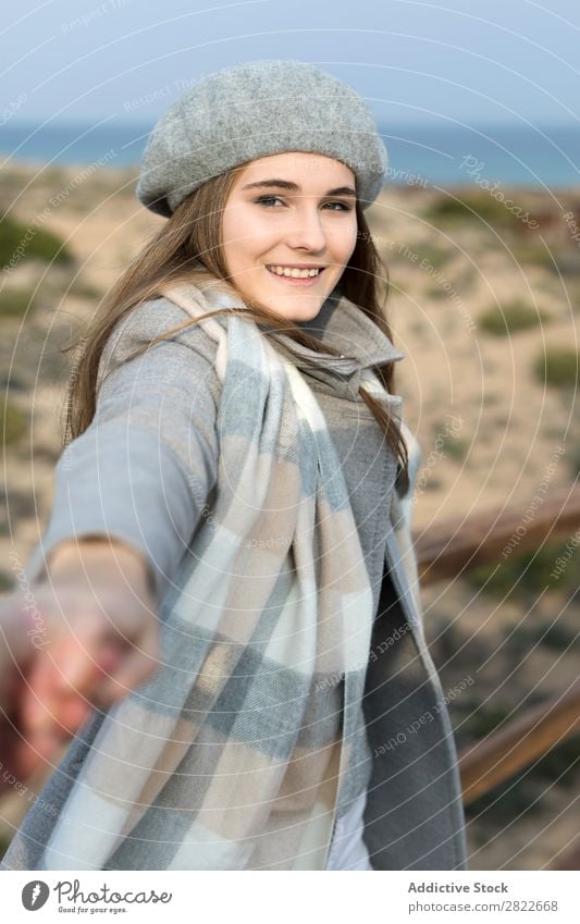 Stilvolle Frau hält die Hand des Fotografen. hübsch Jugendliche schön attraktiv Promenade Gang Holz Natur Baskenmütze mir folgen gestikulieren Mensch