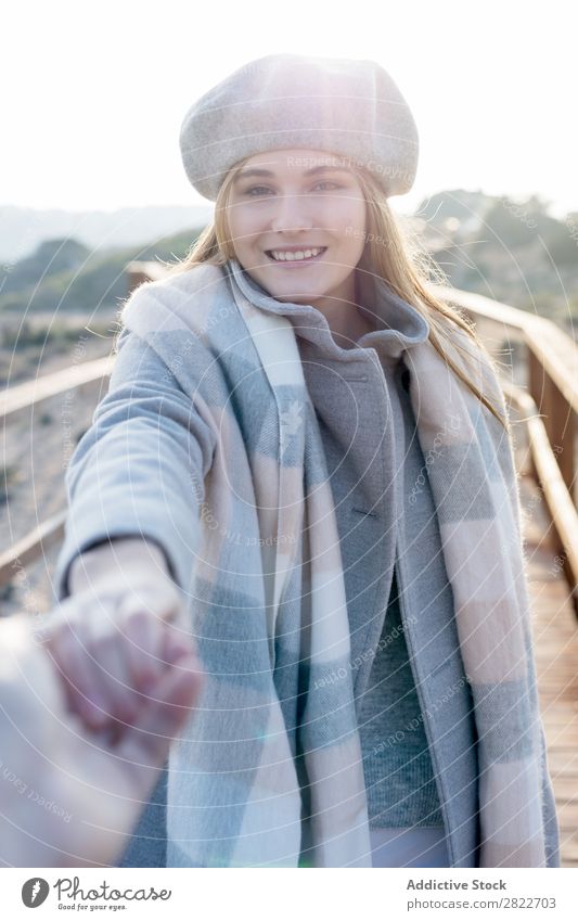 Stilvolle Frau hält die Hand des Fotografen. hübsch Jugendliche schön attraktiv Promenade Gang Holz Natur Baskenmütze mir folgen gestikulieren Mensch