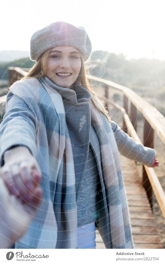 Stilvolle Frau hält die Hand des Fotografen. hübsch Jugendliche schön attraktiv Promenade Gang Holz Natur Baskenmütze mir folgen gestikulieren Mensch