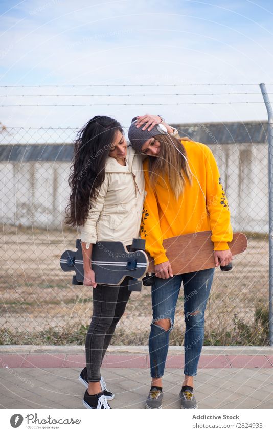 Zwei Mädchen, die auf der Straße mit Longboard spielen. Energie Frau Mensch Freizeit & Hobby Bewegung Tourist Glück Abenteuer Aktion Freiheit Model trendy