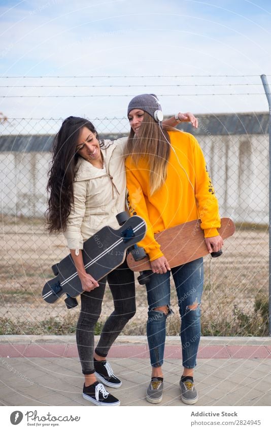 Zwei Mädchen, die auf der Straße mit Longboard spielen. Energie Frau Mensch Freizeit & Hobby Bewegung Tourist Glück Abenteuer Aktion Freiheit Model trendy