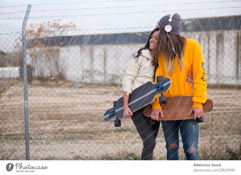 Zwei Mädchen, die auf der Straße mit Longboard spielen. Energie Frau Mensch Freizeit & Hobby Bewegung Tourist Glück Abenteuer Aktion Freiheit Model trendy