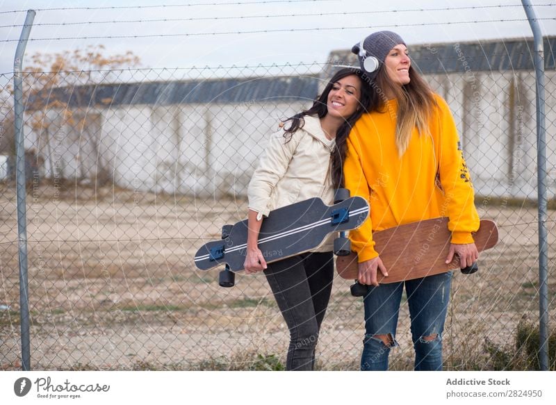 Zwei Mädchen, die auf der Straße mit Longboard spielen. Energie Frau Mensch Freizeit & Hobby Bewegung Tourist Glück Abenteuer Aktion Freiheit Model trendy