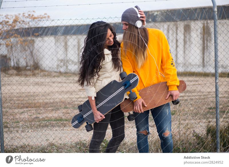 Zwei Mädchen, die auf der Straße mit Longboard spielen. Energie Frau Mensch Freizeit & Hobby Bewegung Tourist Glück Abenteuer Aktion Freiheit Model trendy