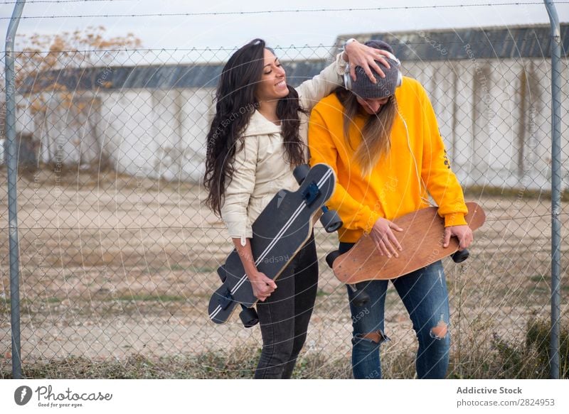 Zwei Mädchen, die auf der Straße mit Longboard spielen. Energie Frau Mensch Freizeit & Hobby Bewegung Tourist Glück Abenteuer Aktion Freiheit Model trendy