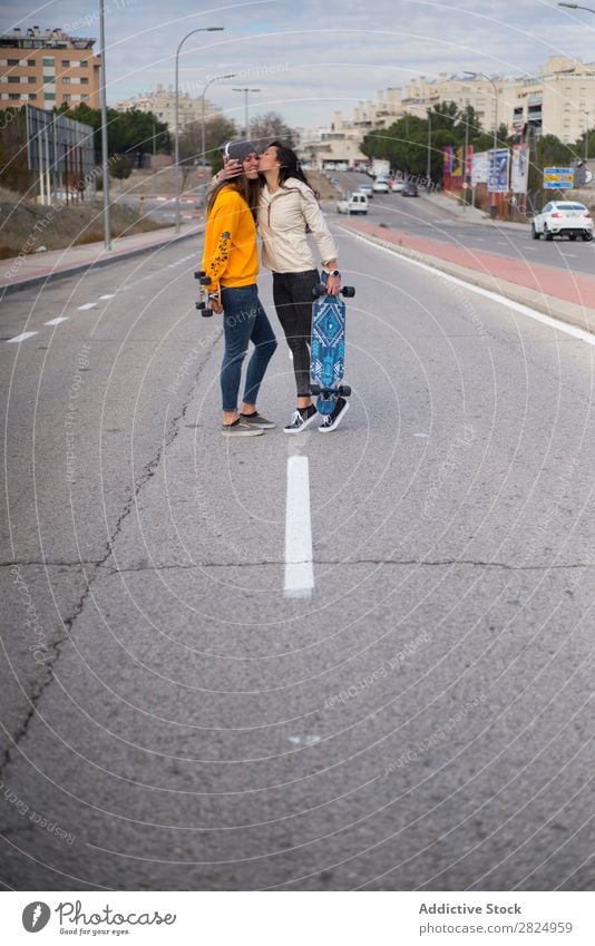 Zwei Mädchen, die auf der Straße mit Longboard spielen. Energie Frau Mensch Freizeit & Hobby Bewegung Tourist Glück Abenteuer Aktion Freiheit Model trendy