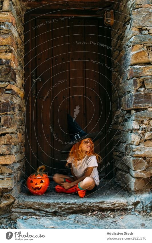 Liebenswertes Mädchen, das auf der Veranda posiert. Halloween so tun, als ob erschrecken Körperhaltung Porträt heiter Haus Kostüm Feste & Feiern Tradition