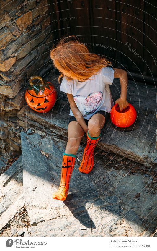 Charmant auf der Veranda sitzend Mädchen Halloween Kürbis Gast Tradition Dekor Design Ferien & Urlaub & Reisen Herbst Festspiele Kind Kindheit Fröhlichkeit