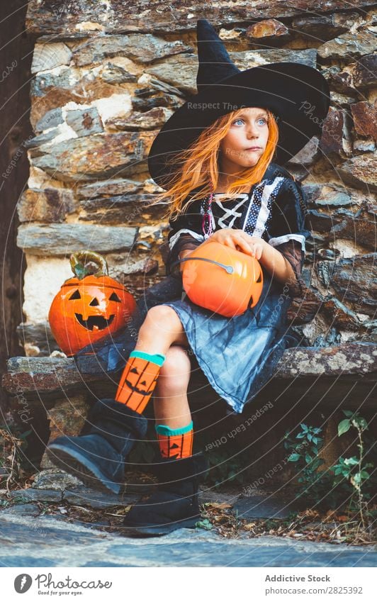 Kleines Mädchen in Hexenkostüm auf der Bank sitzend Halloween Süßwaren Essen Hundefutter Ferien & Urlaub & Reisen Entertainment Festspiele Jahreszeiten Kostüm